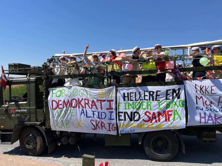 Studenterbilen 'Party Non-Stop', smukt dekoreret med farverige bannere og festlig pynt, der symboliserer fejringen af de glade studenter. Billederne viser begejstrede studenter i bilen, der spreder feststemning under deres køretur gennem byen