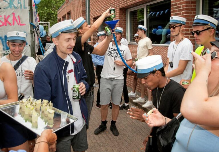 Glade studenter klar til festlig studenterkørsel i Nicedrive studentervogn, model 'Discovognen', dekoreret med bannere og danske flag, tilgængelig til en billig pris