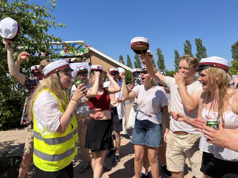 Glade studenter klar til festlig studenterkørsel i Nicedrive studentervogn, model 'Energibomben', dekoreret med bannere og danske flag, tilgængelig til en billig pris