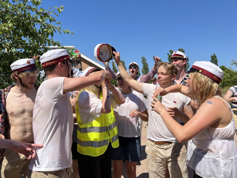 Glade studenter foran Nicedrive studentervogn, model 'Monster Truck 2', danner espalier med deres studenterhuer på studenterkørsel på en solrig dag, tilgængelig til en billig pris