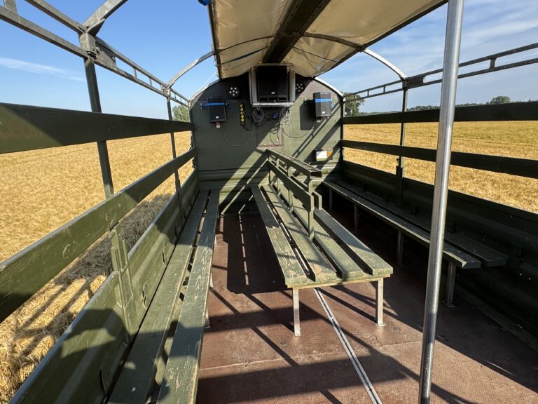 Indvendig visning af Nicedrive studentervogn, model ‘Stripperstangen’, til studenterkørsel, siddepladser, kopholder, discolys og musikanlæg, tilgængelig til en billig pris