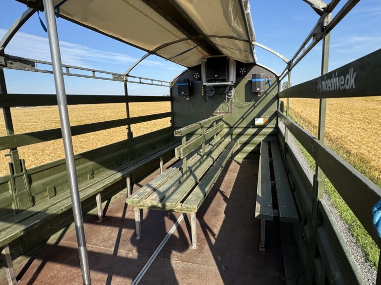 Indvendig visning af Nicedrive studentervogn, model ‘Stripperstangen’, til studenterkørsel, siddepladser, kopholder, discolys og musikanlæg, tilgængelig til en billig pris