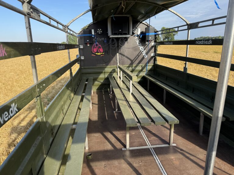 Indvendig visning af Nicedrive studentervogn, model ‘Young Party’, til studenterkørsel, siddepladser, kopholder, discolys og musikanlæg, tilgængelig til en billig pris