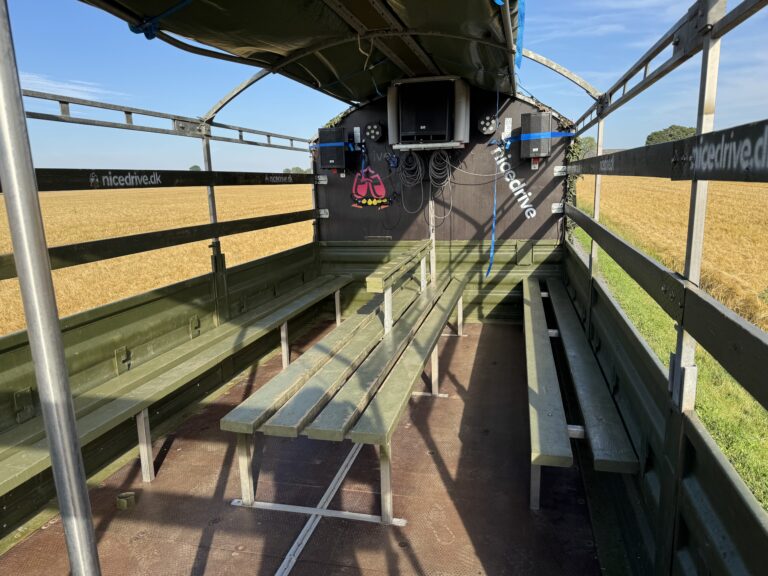 Indvendig visning af Nicedrive studentervogn, model ‘Young Party’, til studenterkørsel, siddepladser, kopholder, discolys og musikanlæg, tilgængelig til en billig pris