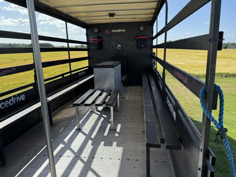 Indvendig visning af Nicedrive studentervogn, model ‘Energizer’, til studenterkørsel, siddepladser, stripperstang, kopholder, discolys og musikanlæg, tilgængelig og ledig til en billig pris