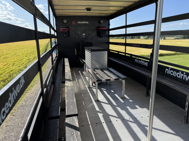 Indvendig visning af Nicedrive studentervogn, model ‘Energizer’, til studenterkørsel, siddepladser, stripperstang, kopholder, discolys og musikanlæg, tilgængelig og ledig til en billig pris
