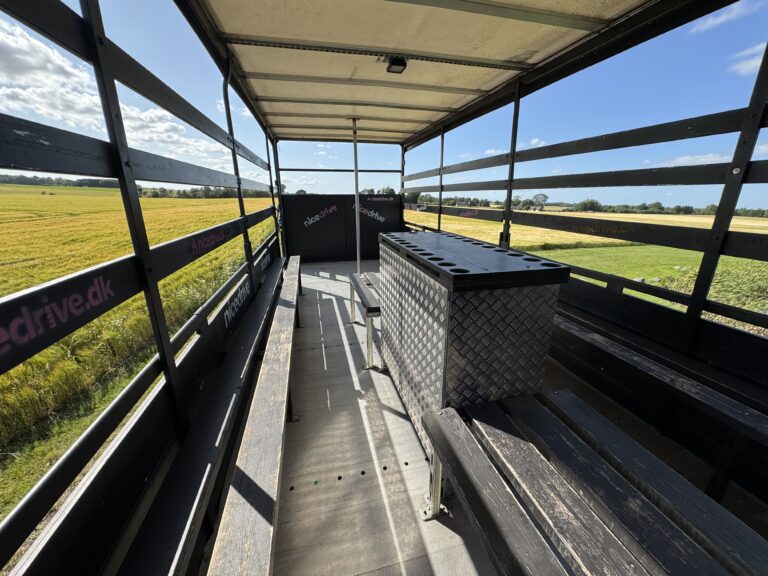 Indvendig visning af Nicedrive studentervogn, model ‘Energizer’, til studenterkørsel, siddepladser, stripperstang, kopholder, discolys og musikanlæg, tilgængelig og ledig til en billig pris