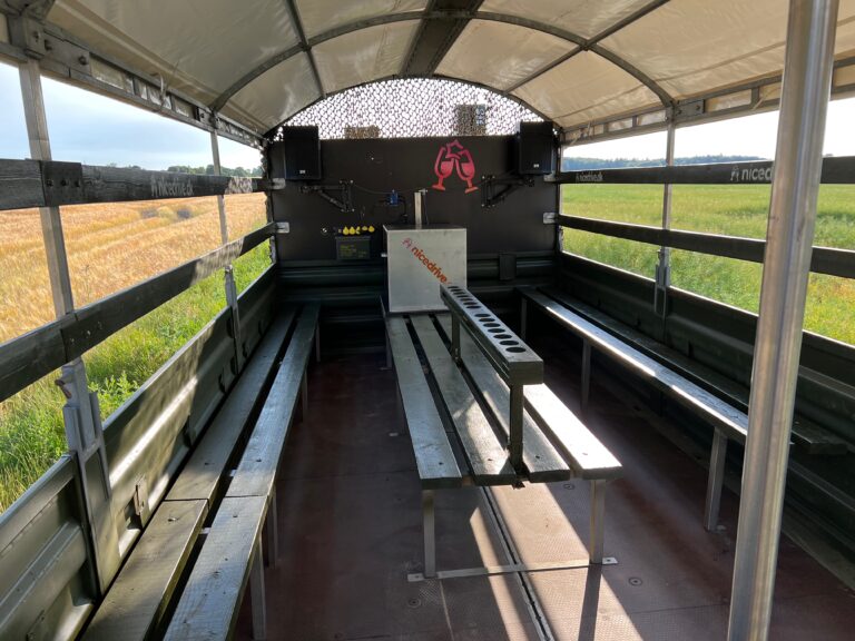 Indvendig visning af Nicedrive studentervogn, model ‘Party Non-Stop’, til studenterkørsel, siddepladser, stripperstang, kopholder, discolys og musikanlæg, tilgængelig og ledig til en billig pris