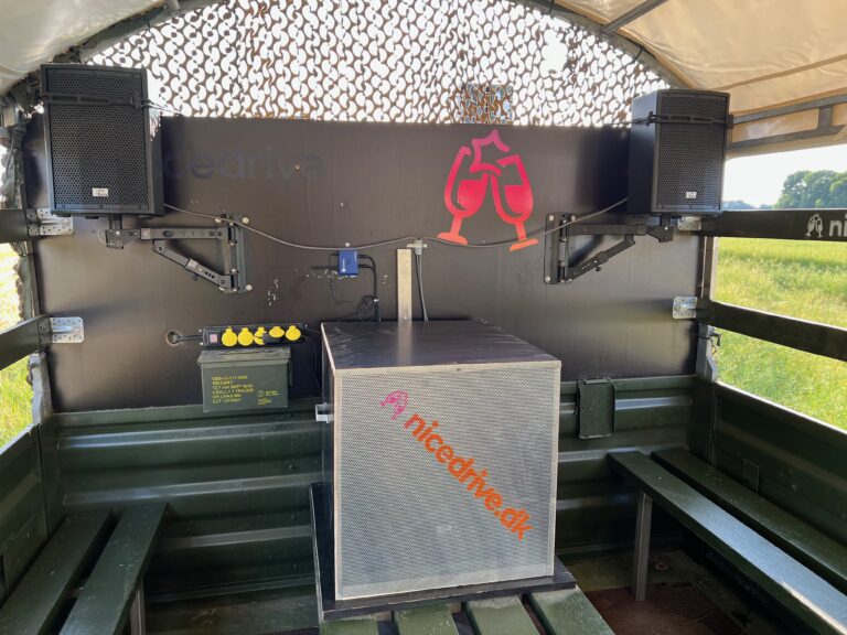 Indvendig visning af Nicedrive studentervogn, model ‘Partybomb’, til studenterkørsel, siddepladser, stripperstang, kopholder, discolys og musikanlæg, tilgængelig og ledig til en billig pris