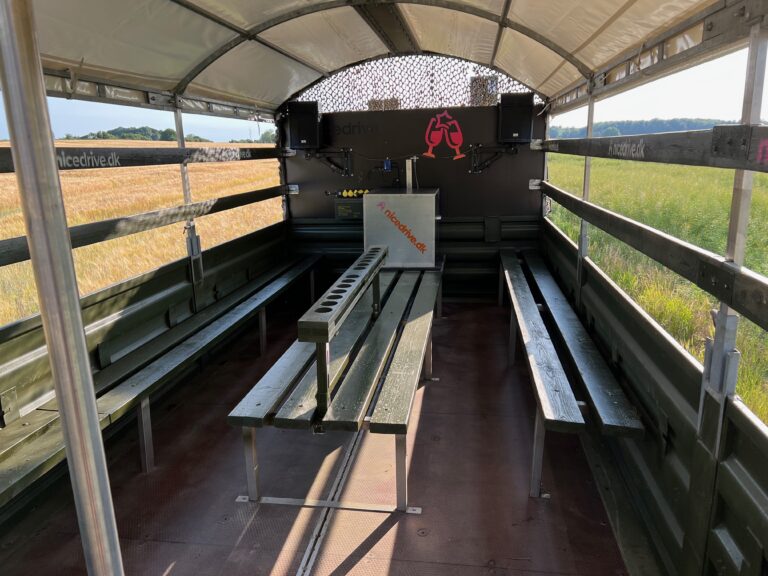 Indvendig visning af Nicedrive studentervogn, model ‘Partybomb’, til studenterkørsel, siddepladser, stripperstang, kopholder, discolys og musikanlæg, tilgængelig og ledig til en billig pris