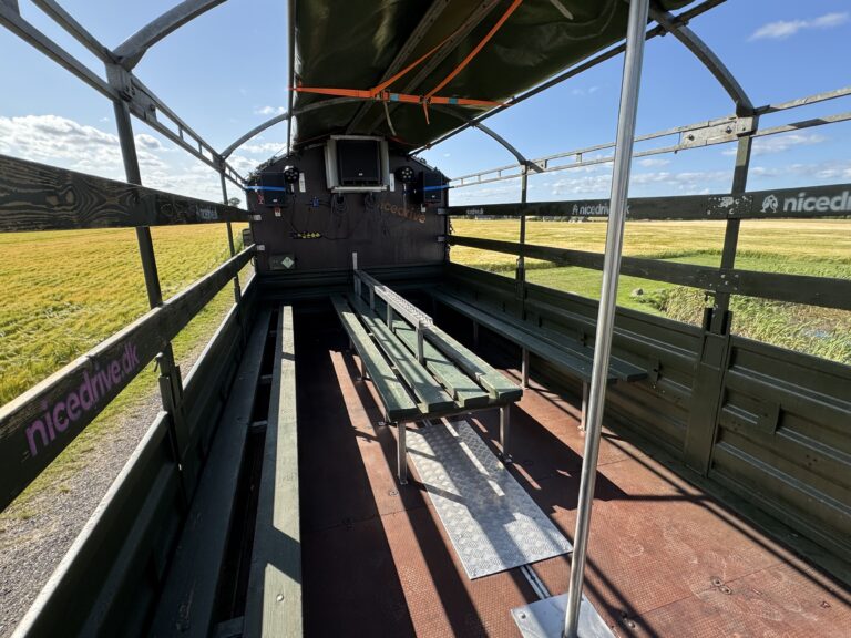 Indvendig visning af Nicedrive studentervogn, model ‘Powershot’, til studenterkørsel, siddepladser, stripperstang, kopholder, discolys og musikanlæg, tilgængelig og ledig til en billig pris