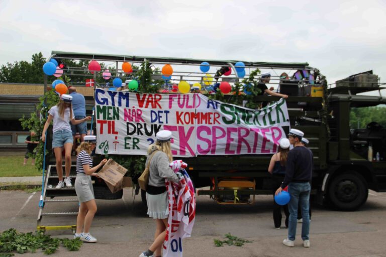 Studentervogn pyntes med balloner og banner før studenterkørsel